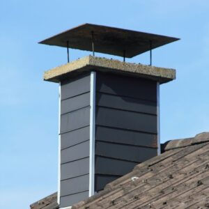 a gray chimney chase with a chimney cap